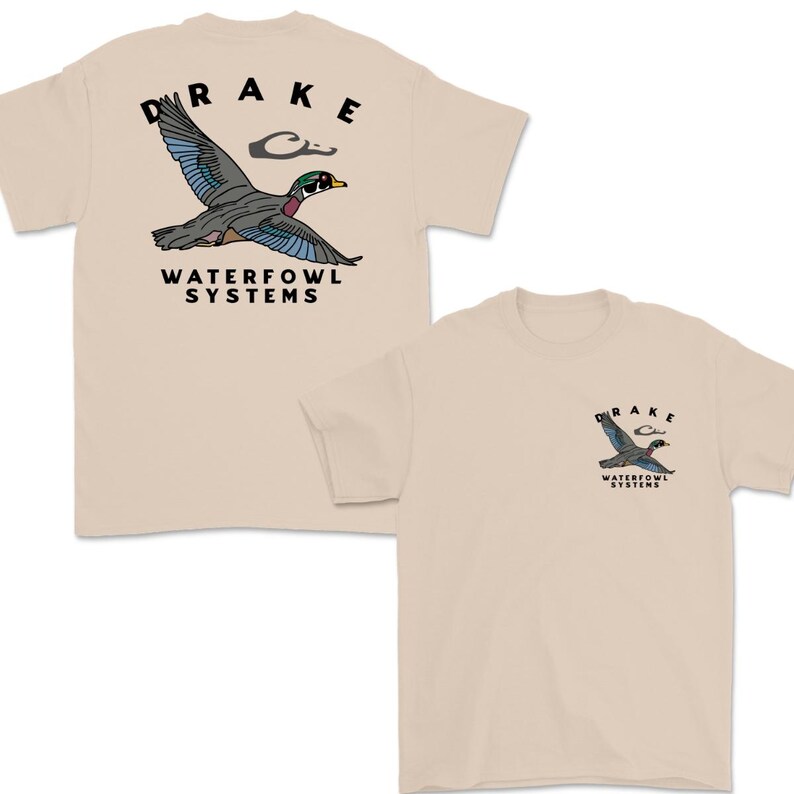 May include: Tan t-shirts with a duck graphic. One shirt has a large duck graphic on the back with the word "DRAKE" above it and "WATERFOWL SYSTEMS" below. The other shirt has a smaller duck graphic on the front.