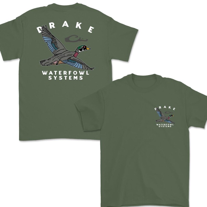 May include: Olive green t-shirts featuring a graphic of a flying duck with sunglasses. The word "DRAKE" is arched above the duck, and "WATERFOWL SYSTEMS" is printed below. One shirt has the graphic on the back, and the other on the front.