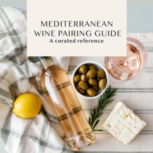 Peut inclure: Nature morte avec une bouteille de vin rosé, un verre de vin, des olives, du fromage, un citron et des brins de romarin. Le texte "MEDITERRANEAN WINE PAIRING GUIDE" est affiché.