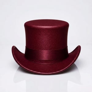 May include: A deep burgundy top hat with a flat crown and a curved brim. The hat features a matching satin ribbon band wrapped around the base of the crown, providing a smooth, uniform texture across the entire surface of the headwear piece.