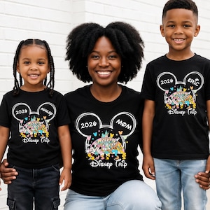May include: Three people wearing matching black t-shirts with a Disney theme. The shirts feature a Mickey Mouse head design with the year "2026" and the words "Disney Trip". One shirt says "Mom", another says "Ashley", and the third says "Eric".