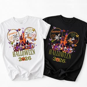 May include: A white t-shirt and a black t-shirt, each featuring a colorful Halloween graphic with a castle, Disney characters in costumes, fireworks, and the text "HALLOWEEN 2026". The white shirt includes the name "PAMELA" and the black shirt "GEORGE".