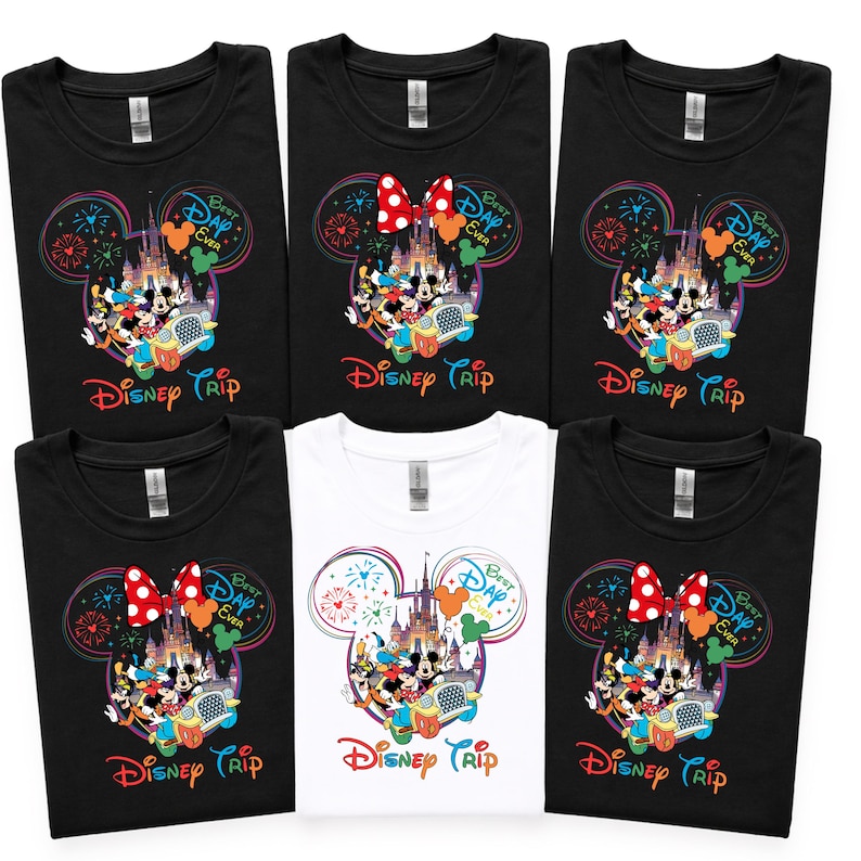 Puede incluir: Seis camisetas, cinco negras y una blanca, con un colorido dise&ntilde;o de Disney Trip. El dise&ntilde;o incluye orejas de Mickey Mouse, fuegos artificiales, un castillo y el texto "Best Day Ever".