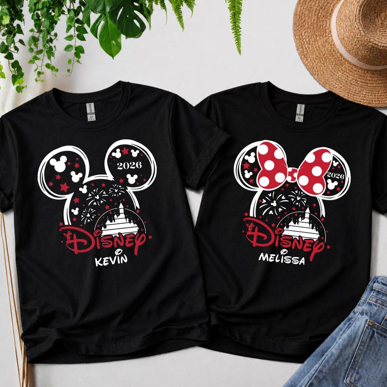 May include: Two black t-shirts with Disney designs. One has a Mickey Mouse head outline with red stars and the name "Kevin." The other features a red polka-dot bow and the name "Melissa." Both shirts include the year "2026."