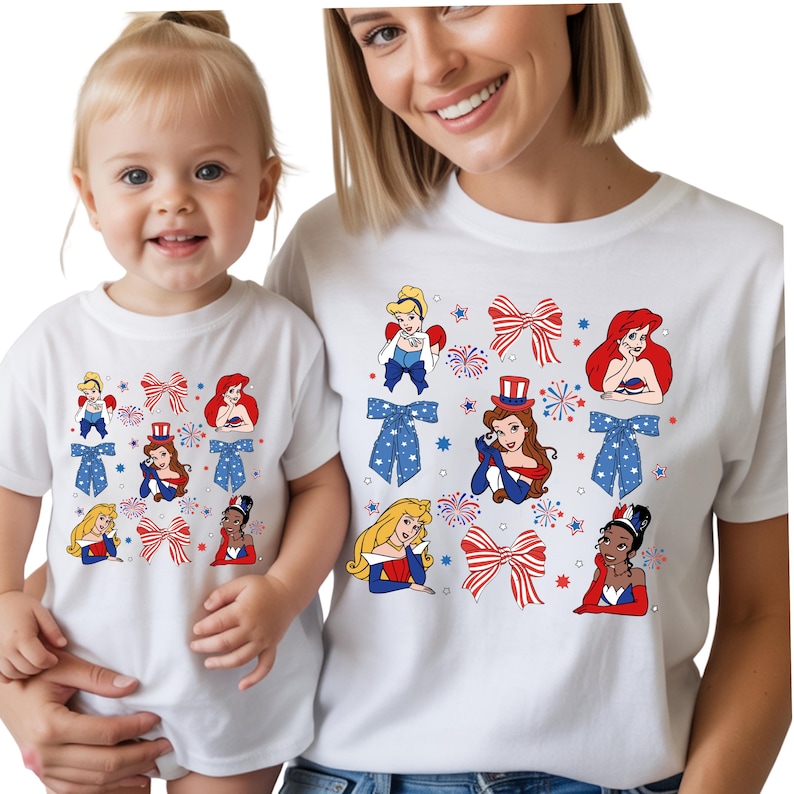 May include: White t-shirts with a patriotic design featuring cartoon princesses, red, white, and blue bows, and fireworks. The shirts are worn by a mother and child, creating a matching set.