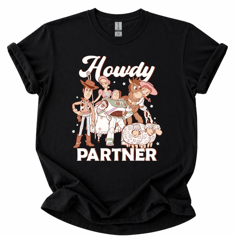 May include: Black t-shirt featuring a graphic of characters from a popular animated movie. The design includes the text "Howdy PARTNER" in white and brown. The shirt showcases a cowboy, space ranger, and other characters.