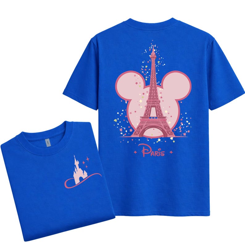 May include: Two blue t-shirts. One shirt features a pink Eiffel Tower design inside a Mickey Mouse head shape with the word "Paris". The other shirt has a pink castle design. Both shirts are short-sleeved.