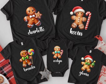 May include: Five black shirts and a bodysuit featuring gingerbread characters with festive accessories like candy canes, lollipops, and hats. Each garment displays a unique name in white script: charlotte, kevin, brenda, evelyn, and gloria.