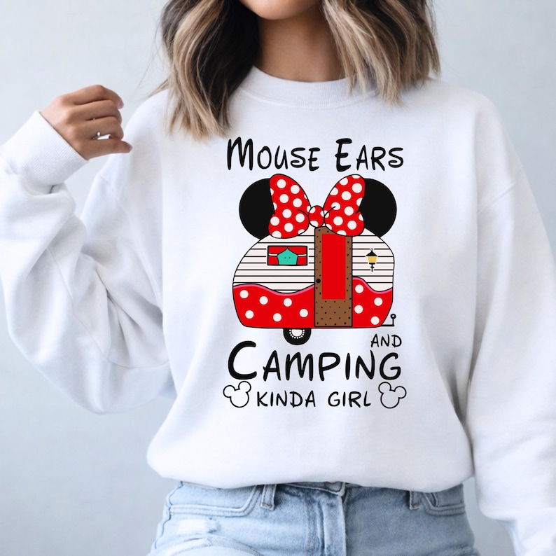 Puede incluir: Sudadera blanca con un dise&ntilde;o de caravana roja y blanca con lunares, con orejas de rat&oacute;n y un lazo. El texto dice "Mouse Ears and Camping Kinda Girl."
