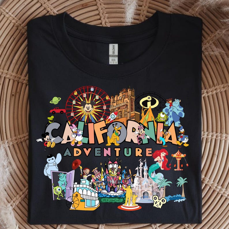 May include: Black t-shirt with a vibrant graphic showcasing Disney characters and attractions. The words "CALIFORNIA ADVENTURE" are printed across the design. The image includes Mickey Mouse, a Ferris wheel, and other well-known Disney elements.