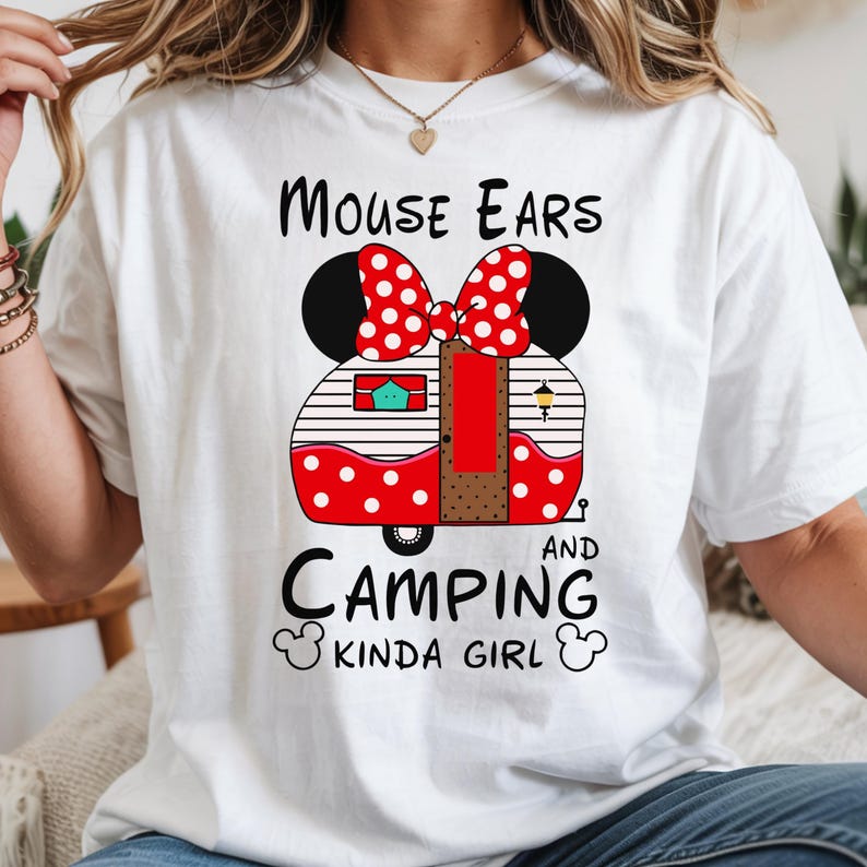 Puede incluir: Camiseta blanca con un lazo de lunares rojos y blancos y orejas de rat&oacute;n negras sobre un dise&ntilde;o de caravana roja y blanca. El texto dice "Mouse Ears and Camping Kinda Girl."