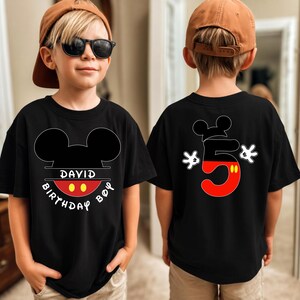 May include: Black t-shirt with a Mickey Mouse design. The front features Mickey Mouse ears, the name "DAVID", and the words "BIRTHDAY BOY". The back displays a large number "5" in red and black, with Mickey Mouse gloves.
