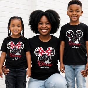 May include: Black t-shirts with a Disney theme. The shirts feature a Minnie Mouse bow design with red polka dots, fireworks, and a castle. The shirts have the text "Disney" and the names "Olivia" and "Oliver" and "Mommy".