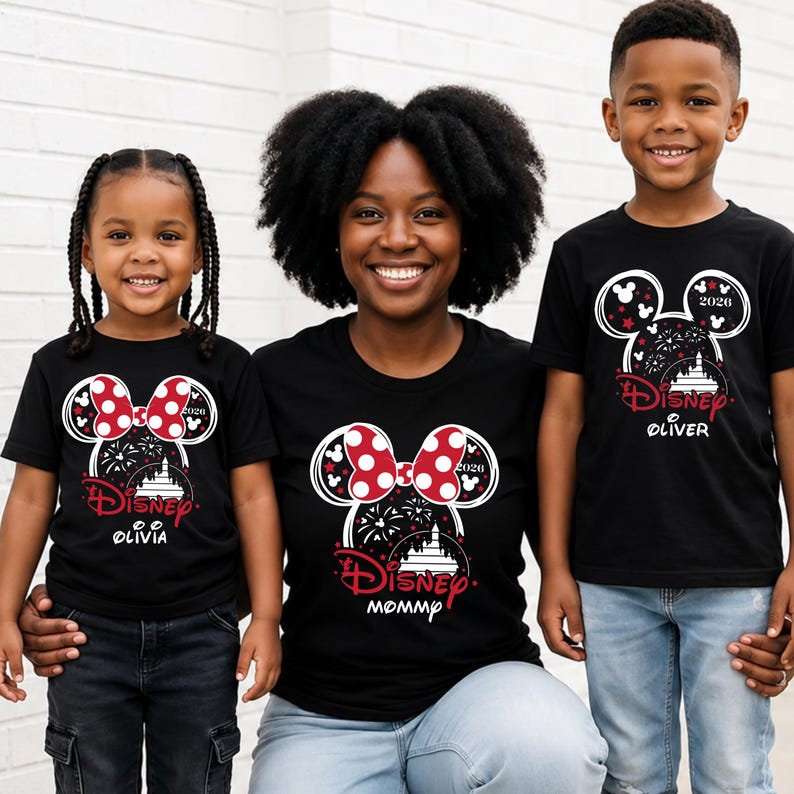 May include: Black t-shirts with a Disney theme. The shirts feature a Minnie Mouse bow design with red polka dots, fireworks, and a castle. The shirts have the text "Disney" and the names "Olivia" and "Oliver" and "Mommy".