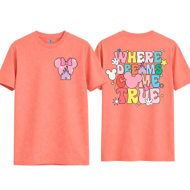 May include: Two coral-coloured t-shirts. One has a pink Minnie Mouse head with a bow and a purple castle on the front. The back of the shirt displays the words "WHERE DREAMS COME TRUE" in colourful bubble letters and Mickey Mouse silhouettes.