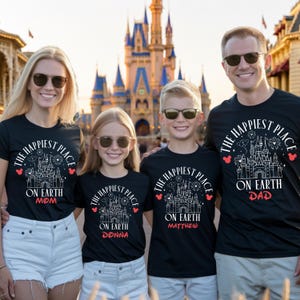 May include: Four people wearing black t-shirts with the text "The Happiest Place on Earth" and a castle graphic. The shirts are personalized with "Mom", "Donna", "Matthew", and "Dad". The background features a large castle.