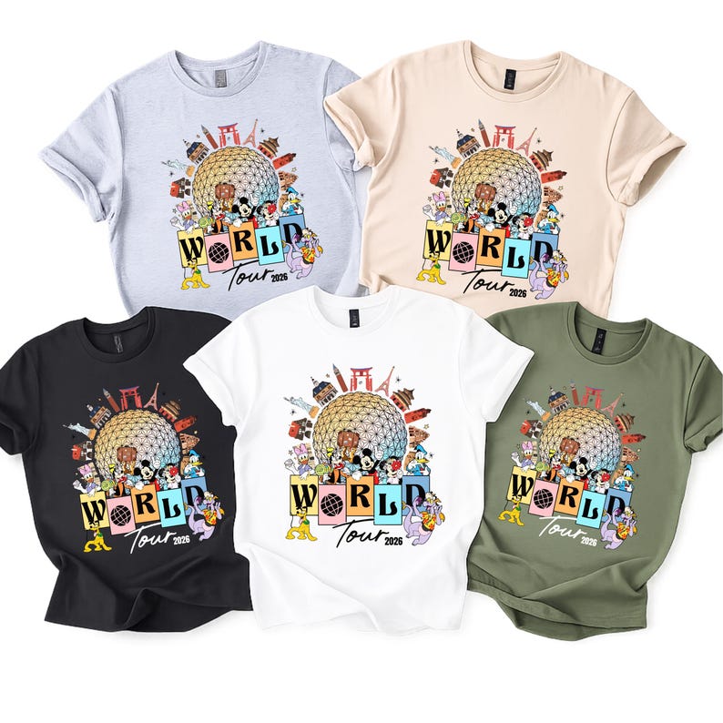 May include: Five short-sleeved t-shirts in light grey, beige, black, white, and olive green. Each shirt displays a colourful graphic with the text "World Tour 2026" and cartoon characters.