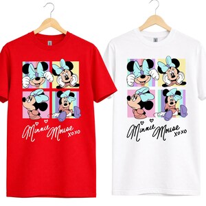 Pu&ograve; includere: T-shirt rosse e bianche con grafica di Minnie Mouse. La grafica include quattro pannelli con diverse pose di Minnie Mouse, un fiocco azzurro chiaro e la scritta "Minnie Mouse xoxo".