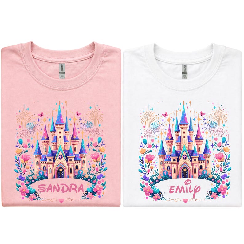 K&ouml;nnte beinhalten: Zwei T-Shirts, eines rosa und eines wei&szlig;en, jeweils mit einem farbenfrohen Schlossdesign. Das Schloss hat blaue, rosa und lila T&uuml;rme, umgeben von Blumen und Feuerwerk. Das rosa Shirt sagt "SANDRA" und das wei&szlig;e Shirt sagt "EMILY".