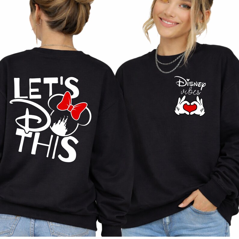 K&ouml;nnte beinhalten: Schwarze Sweatshirts mit Disney-Motiven. Eines zeigt "LET'S DO THIS" mit einem Minnie-Maus-Design und einer roten Schleife. Das andere zeigt "Disney Vibes" mit einer herzf&ouml;rmigen Handgeste und einem roten Herzen.