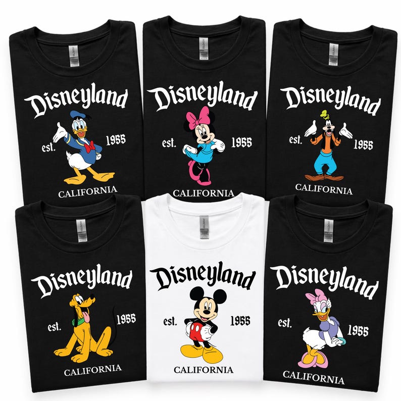 Op de afbeelding: Collectie zwarte en witte t-shirts met Disneyland-personages. Elk shirt toont "Disneyland", "est. 1955 CALIFORNIA", en een ander personage: Donald Duck, Minnie Mouse, Goofy, Pluto, Mickey Mouse en Katrien Duck.