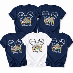 May include: Five navy blue and white t-shirts with a Disney theme. Each shirt features a Mickey Mouse head outline with the year "2026" and the names "Mom", "Dad", "Paul", "Carol", and "Josh". The shirts have a colourful Disney castle and character design.