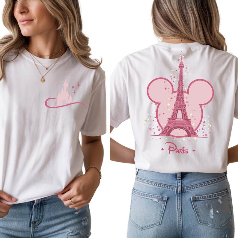 May include: White t-shirt featuring a pink graphic of a castle and a curved line with stars on the front. The back of the shirt has a pink Eiffel Tower design with a Mickey Mouse head outline and the word "Paris".
