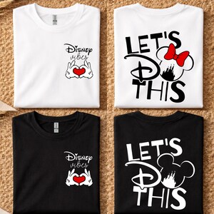 K&ouml;nnte beinhalten: Vier gefaltete T-Shirts, zwei wei&szlig;e und zwei schwarze. Die wei&szlig;en Shirts zeigen den Text "Disney vibes" mit einer herzf&ouml;rmigen Handgeste und "Let's Do This" mit einem Mickey Mouse-Design. Die schwarzen Shirts haben die gleichen Designs.
