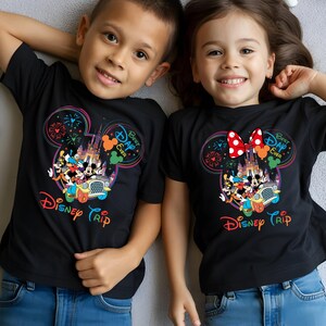 Puede incluir: Dos ni&ntilde;os con camisetas negras con un dise&ntilde;o colorido de Disney. El dise&ntilde;o presenta orejas de Mickey Mouse, un castillo, fuegos artificiales y las palabras "Disney Trip" y "Best Day Ever".