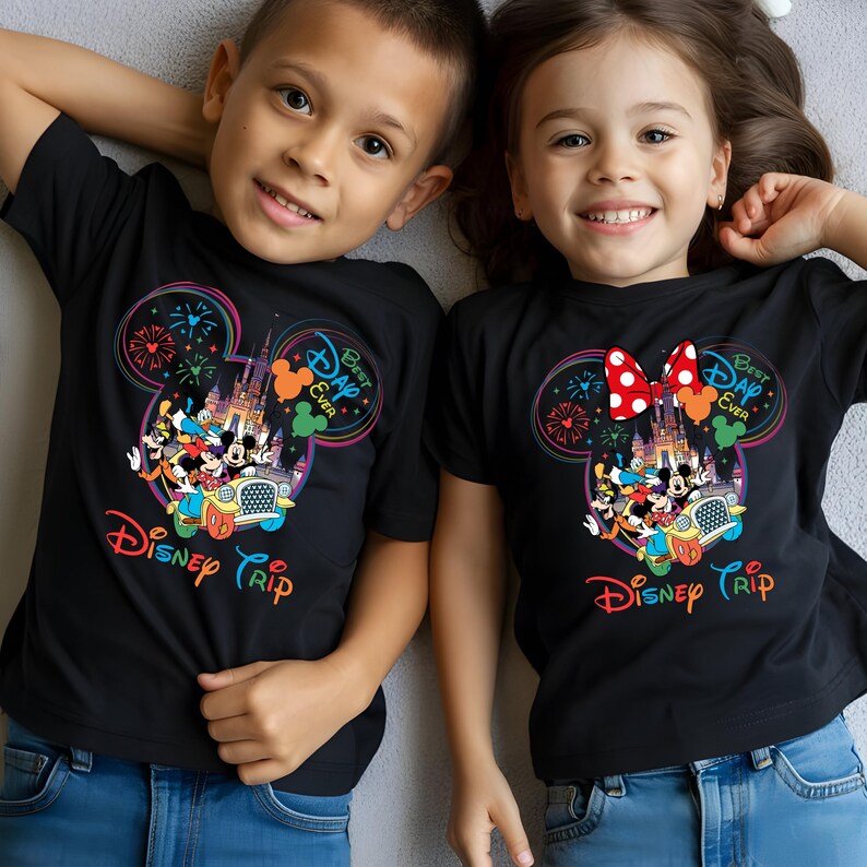 Puede incluir: Dos ni&ntilde;os con camisetas negras con un dise&ntilde;o colorido de Disney. El dise&ntilde;o presenta orejas de Mickey Mouse, un castillo, fuegos artificiales y las palabras "Disney Trip" y "Best Day Ever".