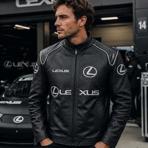 May include: A black leather jacket featuring a stand-up collar, a full-length front zipper, and white piping details on the shoulders. The jacket displays the Lexus brand name and logo in white embroidery on the chest and sleeves.