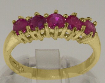 May include: A gold band ring with five pink ruby stones set in a claw setting.