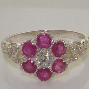May include: A silver ring with a floral design featuring pink gemstones and a clear center stone.