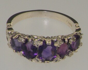 May include: A silver ring with five amethyst gemstones set in a decorative band.