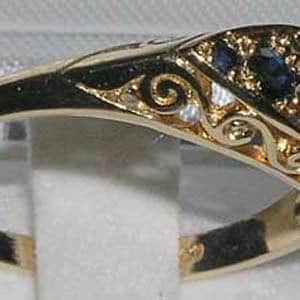 May include: A gold ring with a blue sapphire stone set in a decorative filigree design.