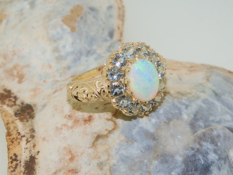May include: A gold ring with a large white opal surrounded by a halo of smaller blue gemstones.
