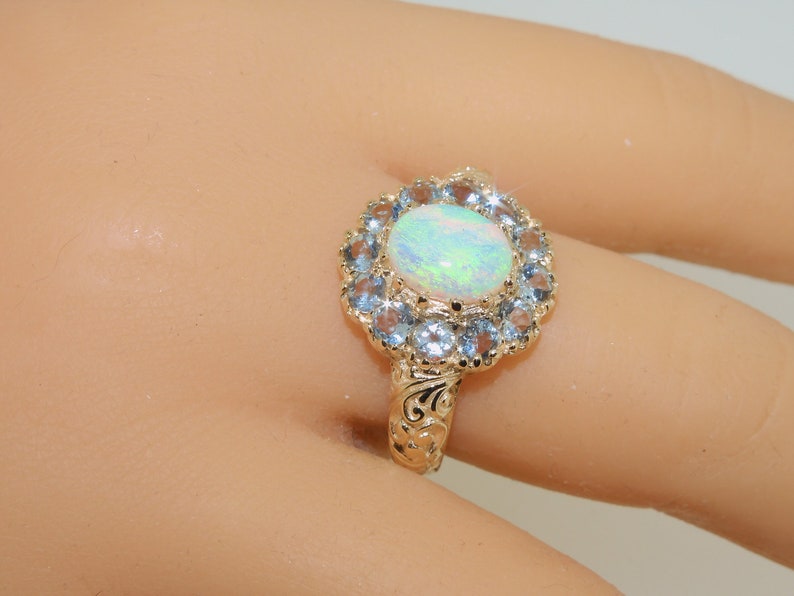 May include: A gold ring with a large oval opal surrounded by a halo of smaller blue gemstones.