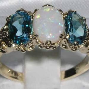 Anillo de oro amarillo de 18 quilates con ópalo de colores y topacio azul de tres piedras, con engaste de garras. Fabricado en Inglaterra. Personalizable.