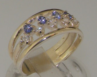 May include: A gold band ring with three blue gemstones and smaller white gemstones set in a delicate design.