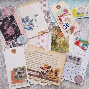 K&ouml;nnte beinhalten: Eine Sammlung von Papier-Ephemera, darunter ein wei&szlig;er Umschlag mit blauen Blumen, ein cremefarbenes Etikett mit einem 34-Cent-Preisschild, eine alte Buchseite, eine Eichh&ouml;rnchen-Illustration, ein Feendruck und ein Etikett mit BLOOM GROW UPRISE.