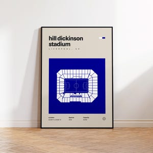 Pode incluir: Um cartaz emoldurado com um diagrama arquitetónico minimalista do Hill Dickinson Stadium em Liverpool, Reino Unido. O design inclui um quadrado azul com um plano de estádio branco, texto preto e dados de localização, ano de abertura 2025 e capacidade de 52.769.