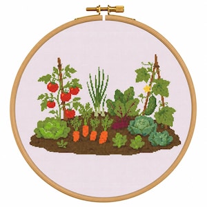 Puede incluir: Bordado de punto de cruz de un huerto, con tomates, zanahorias y repollo, en un aro de madera redondo. El diseño utiliza tonos verdes, naranjas y rojos, con una base de tierra marrón. El aro está asegurado con un tornillo de latón.