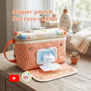 May include: A diaper pouch with a floral pattern and a white wipe dispenser. The pouch has a zipper closure and a handle. The text "Diaper pouch Pattern + Video" is visible in the image. The pouch is open, revealing a changing pad.