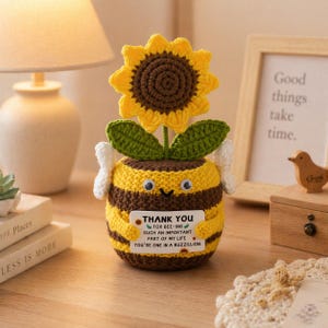 May include: A handcrafted crochet bee ornament with a sunflower. The bee features yellow and brown stripes, googly eyes, and white wings. It holds a card with the words "THANK YOU" and a heartfelt message.
