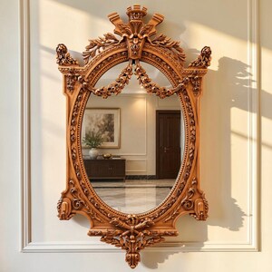 May include: An oval wall mirror featuring a light brown wooden frame with intricate carved floral and leaf motifs. The top of the frame is adorned with a crown-like crest, while the bottom features a decorative finial. The mirror reflects a room.
