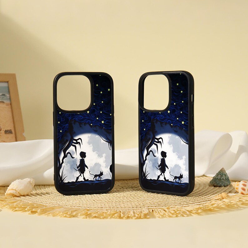 May include: Two black phone cases featuring a graphic illustration of a silhouette of a person walking with a cat under a large white moon, dark blue swirling clouds, and yellow stars against a dark background with a black protective border.