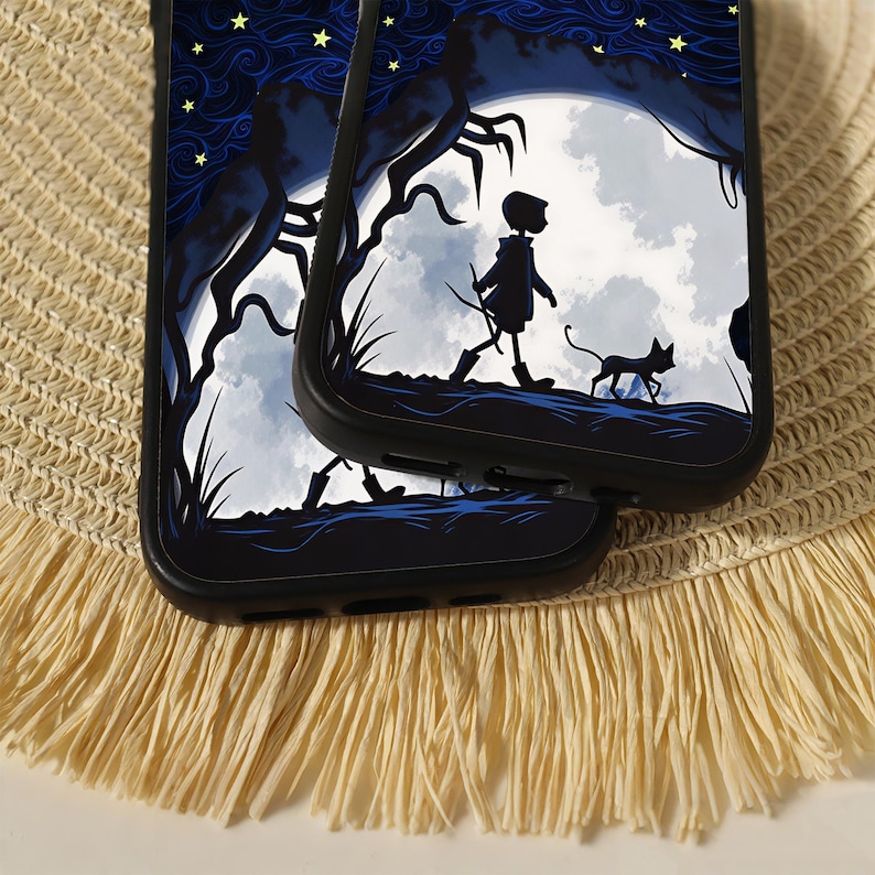 May include: Two black smartphone cases featuring a graphic illustration of a silhouette of a person walking with a cat under a large white moon, surrounded by dark blue swirling clouds and yellow stars against a dark blue night sky background.
