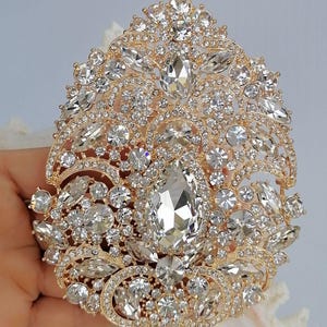 Broche grande em formato de coração com strass e pingente em forma de lágrima, ideal para baile de formatura, casamento e fantasias.