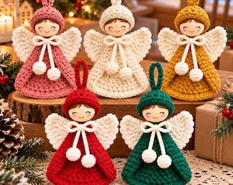 May include: Five crocheted angel ornaments featuring wooden heads with painted faces. Each angel wears a hat and a dress in pink, cream, mustard yellow, red, or dark green, with white crocheted wings and a white cord tie with two small pom-poms.