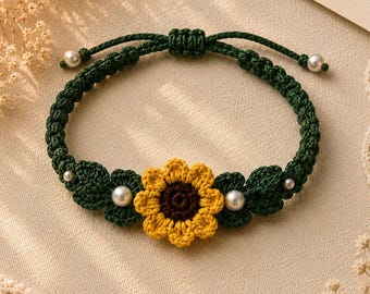 May include: Handmade green macrame bracelet featuring a yellow and brown crochet sunflower and green leaves. The bracelet is adorned with white pearl beads. The adjustable bracelet is a charming accessory.